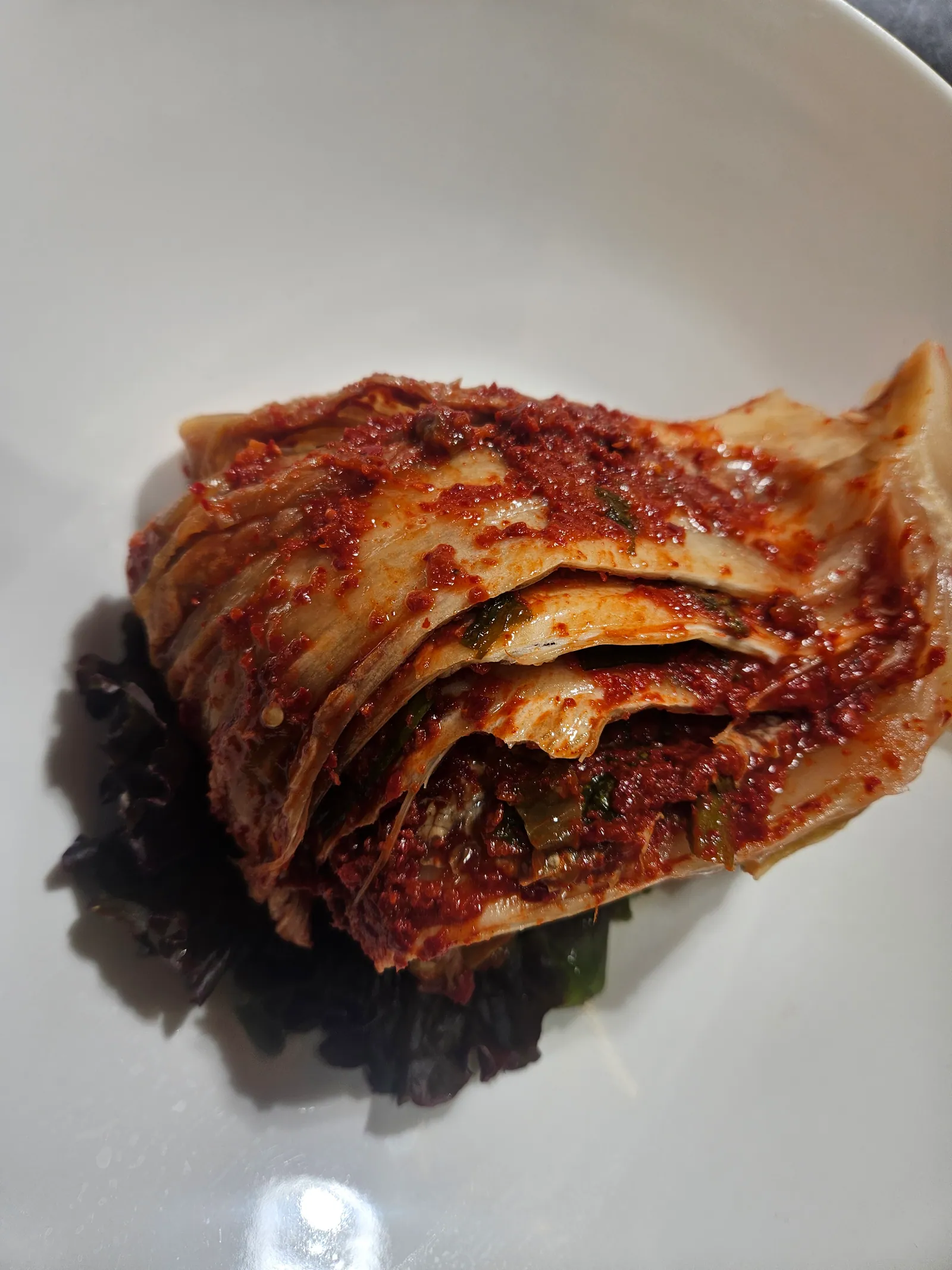 전라도 묵은지 김치찜. 통배추 한 포기를 양념에 올려 쪄 흰 접시에 담았다.