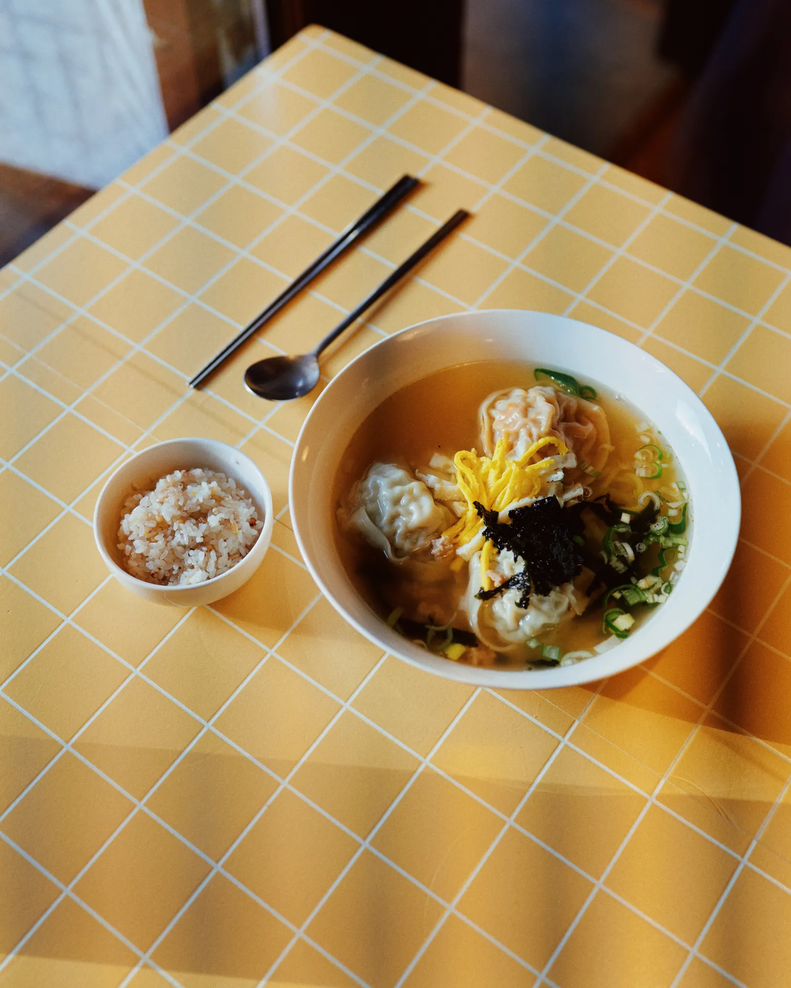 비법육수 손만두국정식. 맑은 육수에 손만두와 달걀 지단, 김, 파를 올렸고 옆에 보리밥 한 공기가 놓여 있다.